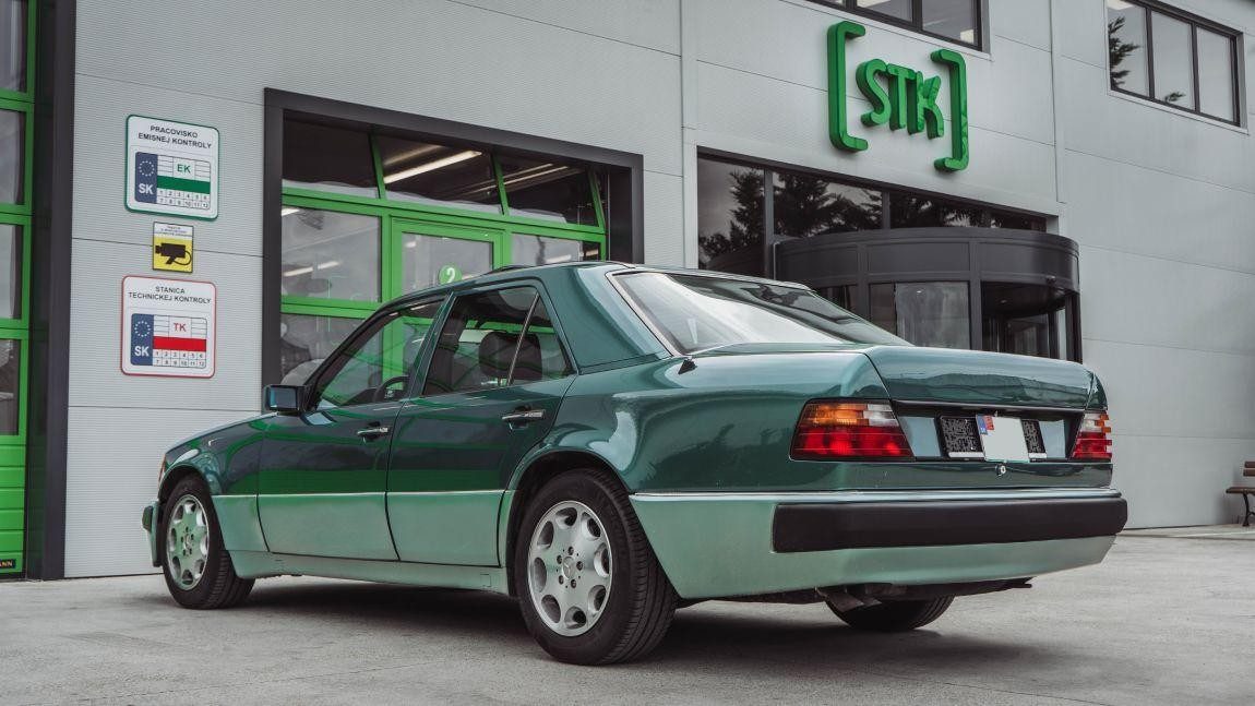 Zelený Mercedes W124 zaparkovaný pred servisom a STK Biga v Bratislave.