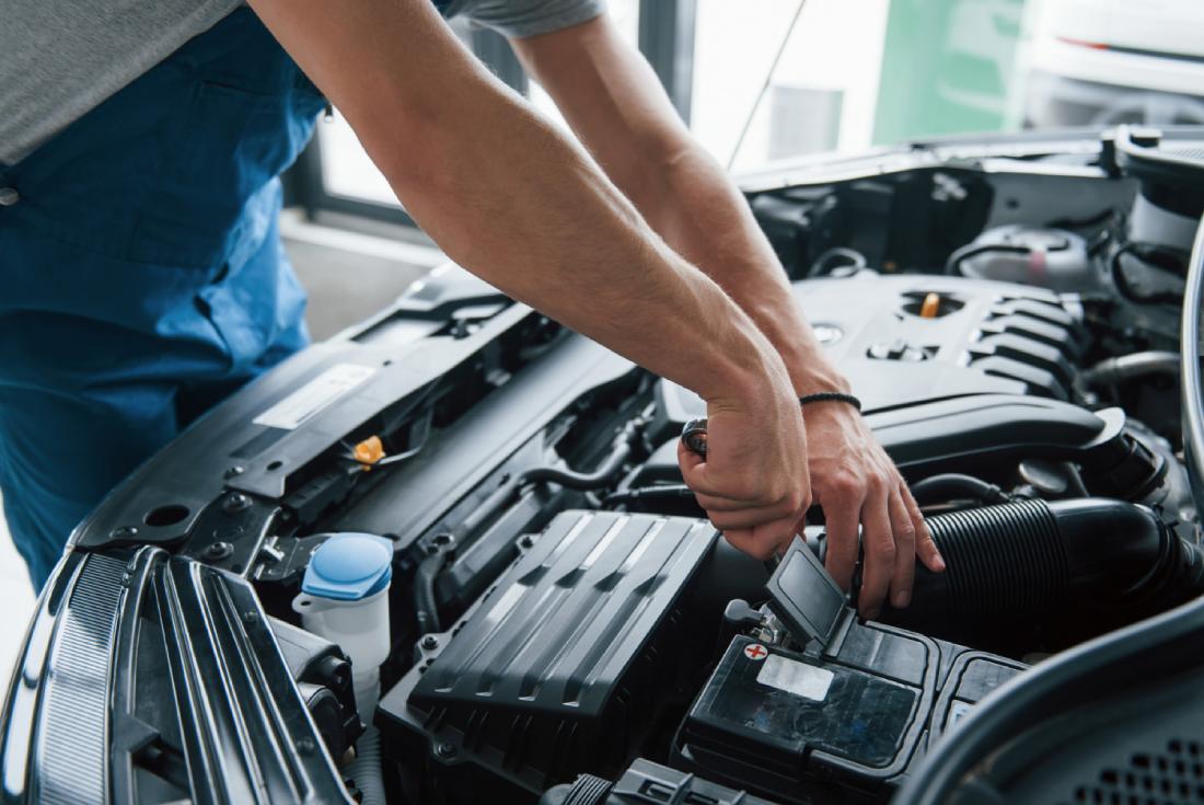 Ruky automechanika opravujúceho auto