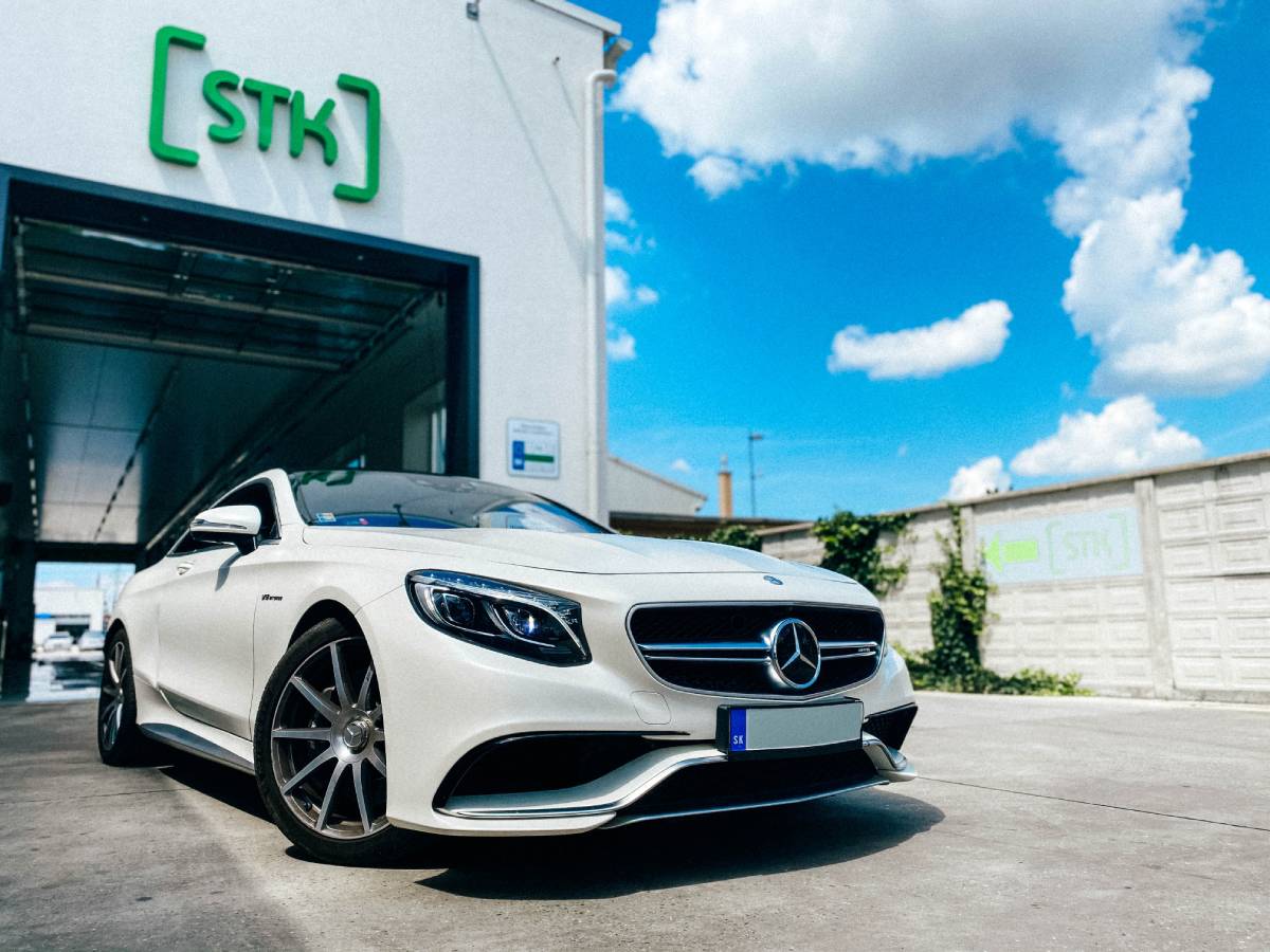 Biele športové auto BMW zaparkované pred budovou BigaSTK.